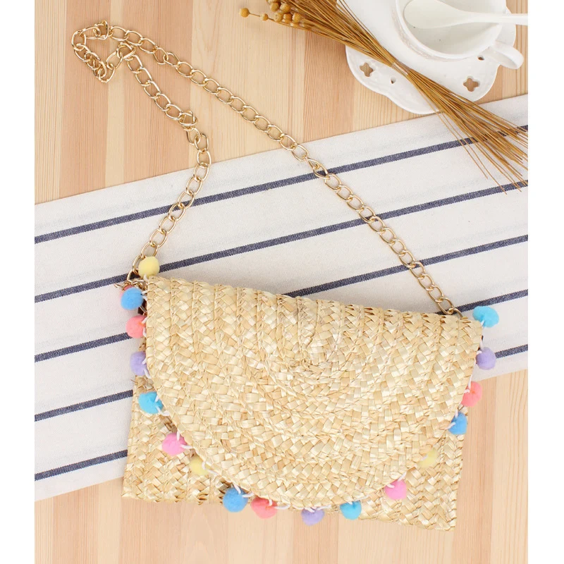 Handgewebte Clutch aus Naturmaterial mit dekorativen Pompons Skanto