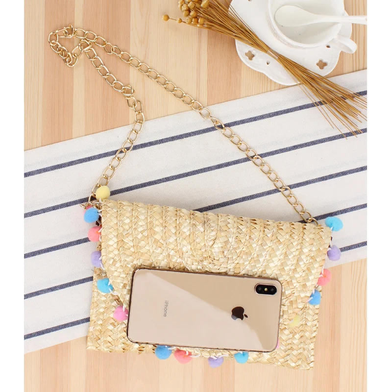 Handgewebte Raffia-Clutch mit dekorativen Pompons Skanto
